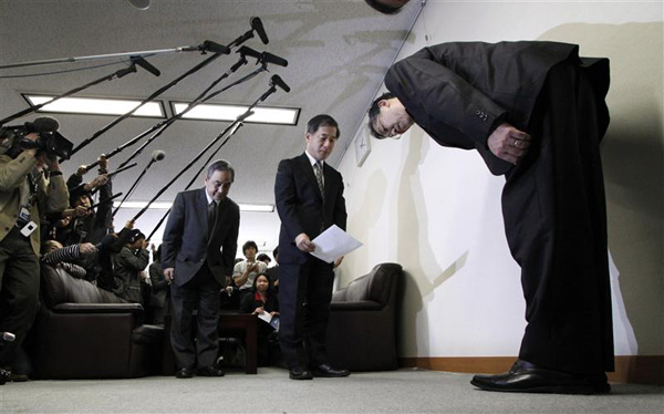 Toyota Motor Corp's managing director Yokoyama bows after he submits a document of a recall in Tokyo